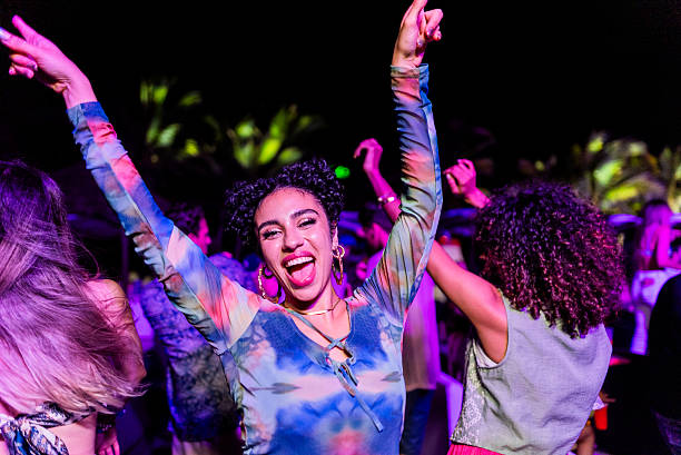 Joyful dancer with raised arms under colorful lights
