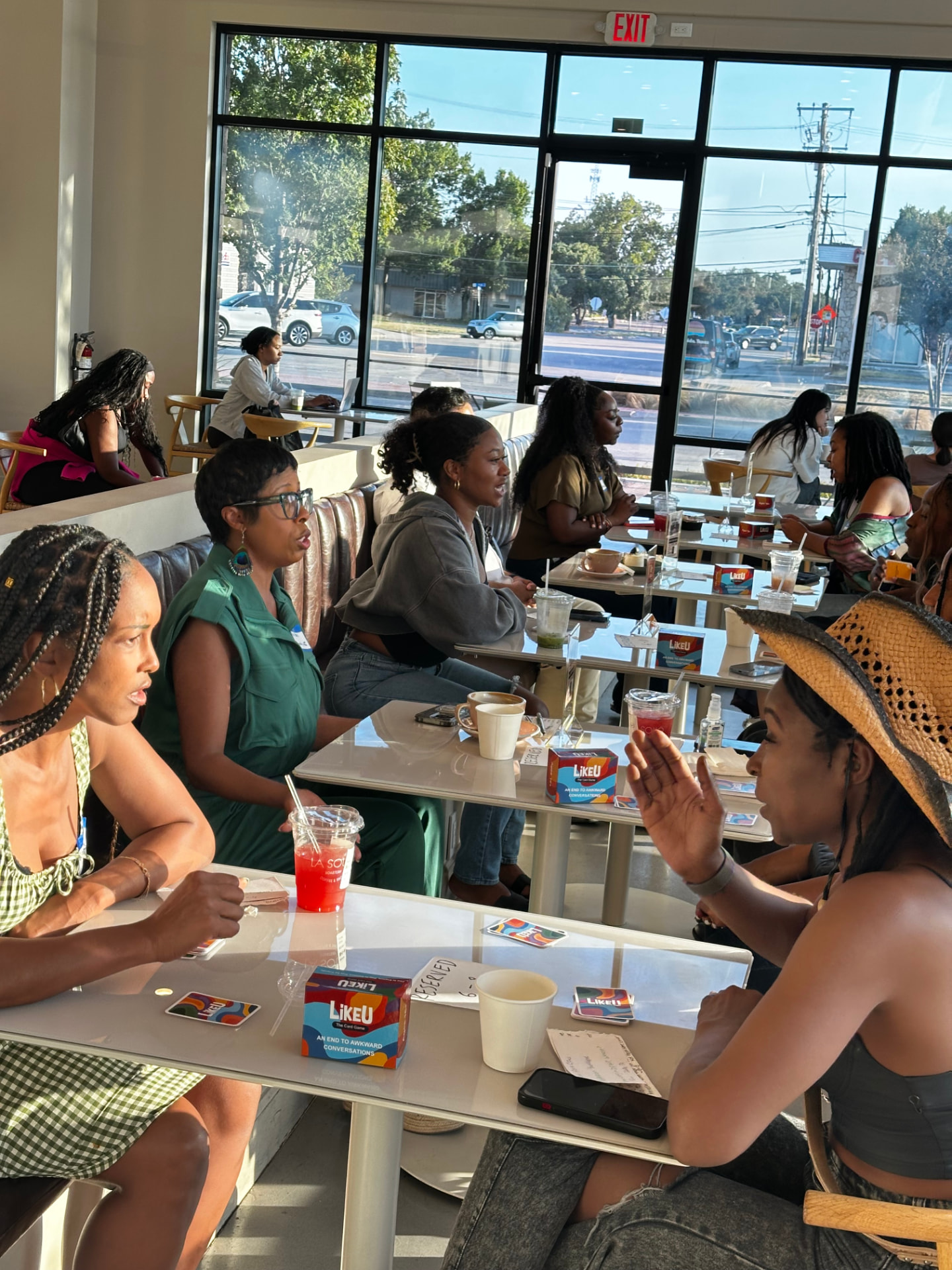 Guests playing a conversation card game in a sunlit cafe
